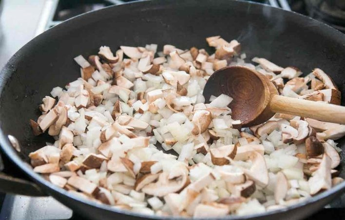 1. Этап. Запеченные спагетти: 2. Верните сковороду на огонь, добавьте столовую ложку масла. Нарежьте мелко лук и грибы, выложите в сковороду сперва лук, затем спустя несколько минут грибы.