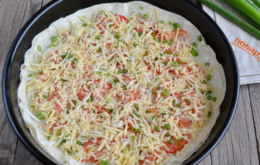 1. Этап. Пицца на лаваше в духовке: Распределите тертый сыр по всей поверхности пиццы. Прогрейте духовку до 200 градусов и поставьте пиццу на 12-15 минут.