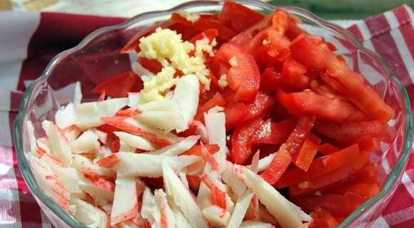 1. Этап. Рыба, запеченная с крабовыми палочками: Рыбу нарезаем порционными кусочками и обжариваем на растительном масле и перекладываем в форму для запекания. Произвольно нарезаем помидоры и крабовые палочки, смешиваем их с измельченным чесноком и майонезом.