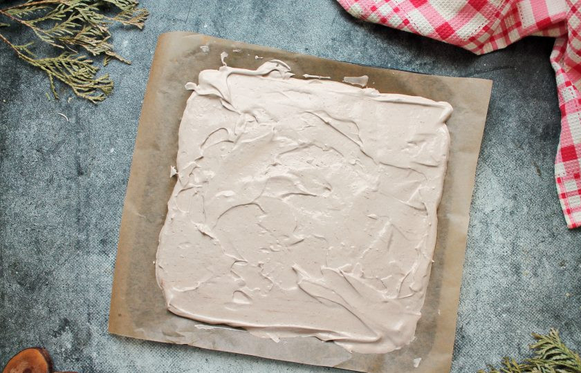 1. Этап. Шоколадный меренговый рулет: Готовое шоколадное тесто переложите на противень с пергаментом и разровняйте ровным слоем толщиной 1.5 сантиметра.