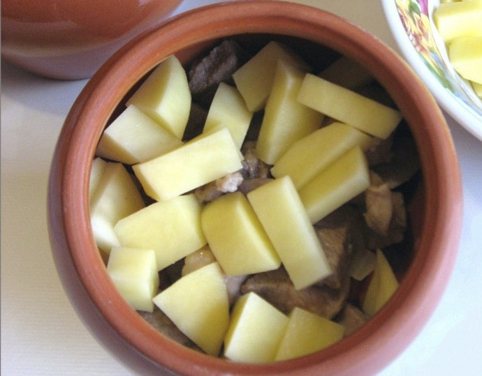 1. Этап. Свинина тушеная в горшочке: 11. Предпоследним идет слой картофеля.