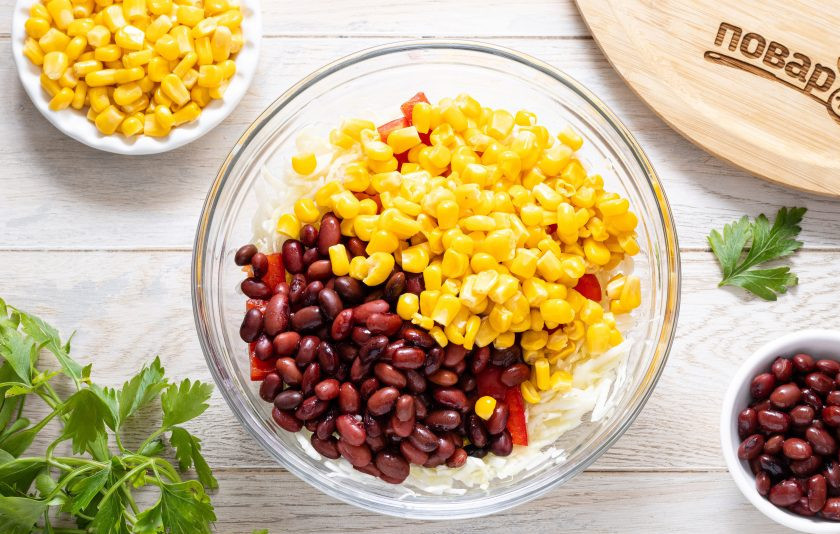 1. Этап. Салат с капустой, фасолью и кукурузой: Слейте жидкость от консервированной фасоли и кукурузы. Фасоль промойте в чистой воде и откиньте на сито, чтобы стекла лишняя жидкость. Переложите в глубокую миску к остальным ингредиентам.