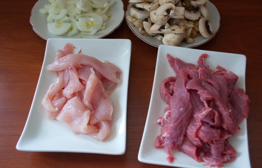 1. Этап. Картофельное рагу с мясом: Очень острым ножом нарежьте мясо говядины и курицы на слайсы. Мясо должно быть без плевы, костей, хрящей, жил.