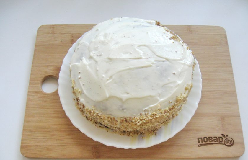 1. Этап. Шоколадный торт с черносливом и орехами: Выложите третий корж. Смажьте верх торта и бока кремом из сметаны и сахарной пудры, который вы отложили. Бока присыпьте измельченными орехами.