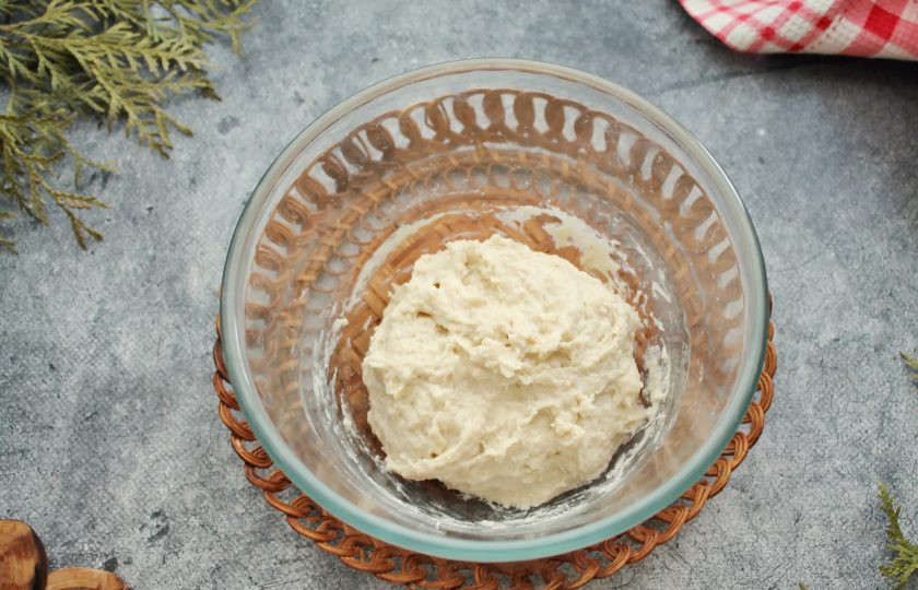 1. Этап. Осетинский пирог с картошкой и сулугуни: Замесите однородное, липкое тесто. Миску с тестом накройте и уберите в теплое место на один час для подъема. Насыпьте на стол муку, выложите подошедшее тесто и вымешивайте до мягкого состояния.