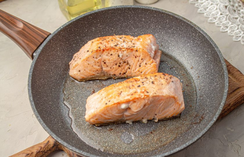 1. Этап. Лосось на подушке из шпината: В сковороде нагрейте масло, обжарьте рыбу со всех сторон по 1 минуте при умеренном нагреве.