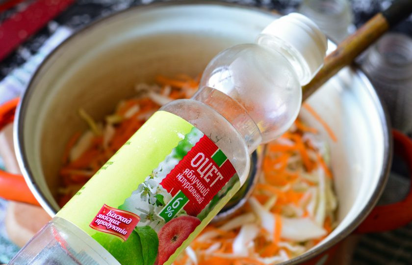 1. Этап. Капуста с морковью на зиму: Влейте уксус и оставьте капусту мариноваться на 30-40 минут на столе. Слегка разомните руками, чтобы выделился сок.