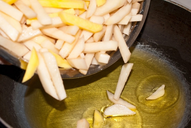 1. Этап. Вкуснейшая жареная картошка: Картофель очищаем и нарезаем произвольными, примерно одинаковыми тонкими ломтиками или брусочками. Разогреваем в глубокой сковороде 4 ст. л. растительного масла и выкладываем картошку. Обжариваем 5 минут на максимальном огне, затем перемешиваем лопаткой и делаем огонь ниже среднего. Жарим под крышкой еще 5 минут.