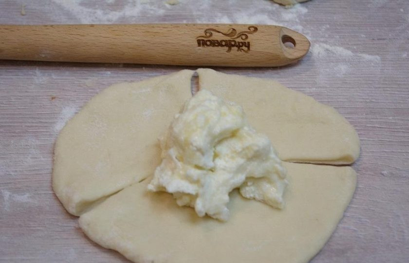 1. Этап. Ватрушки с творогом: 5. На блинчик теста выложите начинку. Для начинки смешайте творог со столовой ложкой сахара и сметаны. Для аромата можно добавить ваниль в начинку. Сметана не даст начинки убежать из ватрушки.