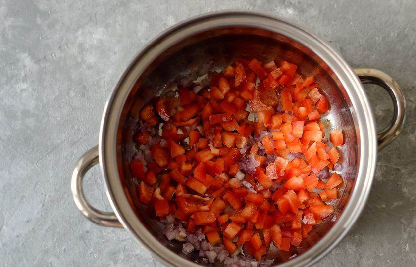 1. Этап. Икра из запеченных баклажанов и перца: Добавьте болгарский перец и обжаривайте 5-6 минут.