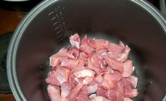 1. Этап. Cвинина в мультиварке Редмонд: В чашу мультиварки вливаем немного растительного масла. Выкладываем порезанную кубиками свинину.