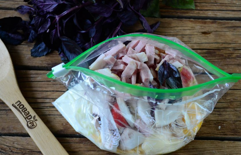 1. Этап. Воздушный омлет в пакете: Ветчину, помидор и гриб мелко порежьте, литья базилика порвите на несколько частей. Все эти ингредиенты положите в пакет.