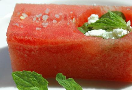 1. Этап. Греческий сыр с мятой в Арбузе: Заполняем ямку сыром и приправляем мятой. Можно слегка приправить солью. Блюдо подается на охлажденной белой тарелке с веточками мяты.