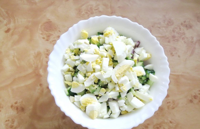 1. Этап. Салат из курицы с рисом: Яйца сварите вкрутую, охладите, очистите и мелко нарежьте. Выложите в салат.