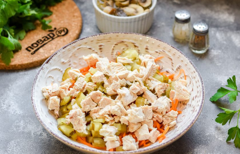 1. Этап. Салат с курицей и маринованными шампиньонами: Куриное филе нарежьте небольшими кубиками и добавьте в салат.