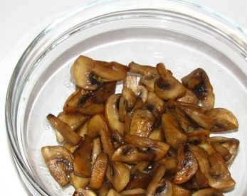 1. Этап. Салат с рыбной консервой: Выкладываем в салатник первым слоем остывшие грибы. Слегка посолим и поперчим.