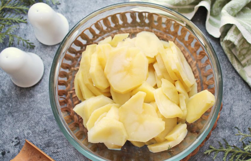 1. Этап. Картошка с копченой курицей в духовке: Картофель почистите, сполосните и порежьте кружочками. Отварите его в соленой воде до готовности и слейте отвар.