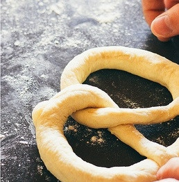 1. Этап. Немецкие брецели: 3. После из каждого шарика сделайте тонкий жгутик и сформируйте вот таким образом кренделек.