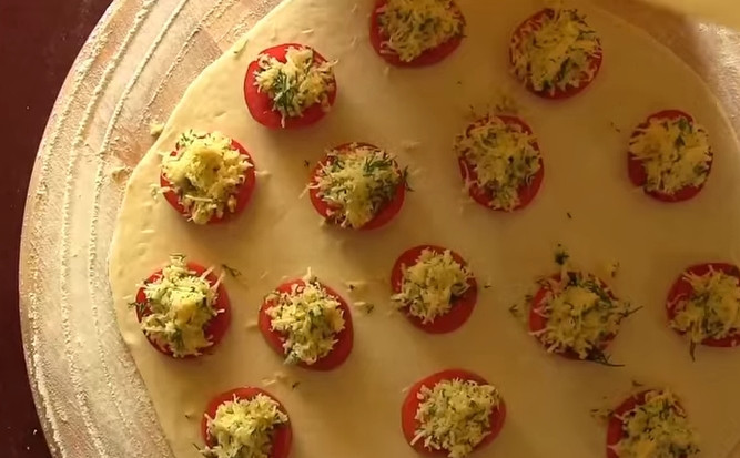 1. Этап. Пирожки Бомбочки без дрожжей: 6. Тесто разделите на 2 части и раскатайте 2 тонких пласта. На одну часть теста выложите помидоры на расстоянии 3 см друг от друга. Сверху уложите сыр с зеленью. Накройте второй частью теста.