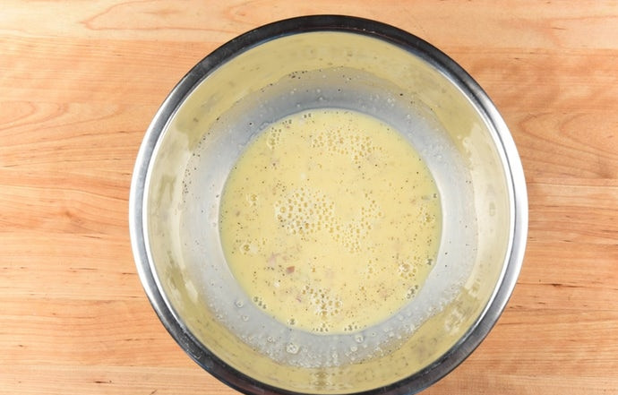 1. Этап. Мини-киш с беконом: Сделайте заливку. Взбейте вместе яйца, соль, лук, молоко и перец.