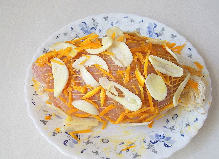 1. Этап. Мраморная индейка: Оставшийся чеснок порежьте тонкими пластинами, цедру тонкой соломкой. Натрите мясо оставшейся солью со всех сторон. Посыпьте чесноком и цедрой.