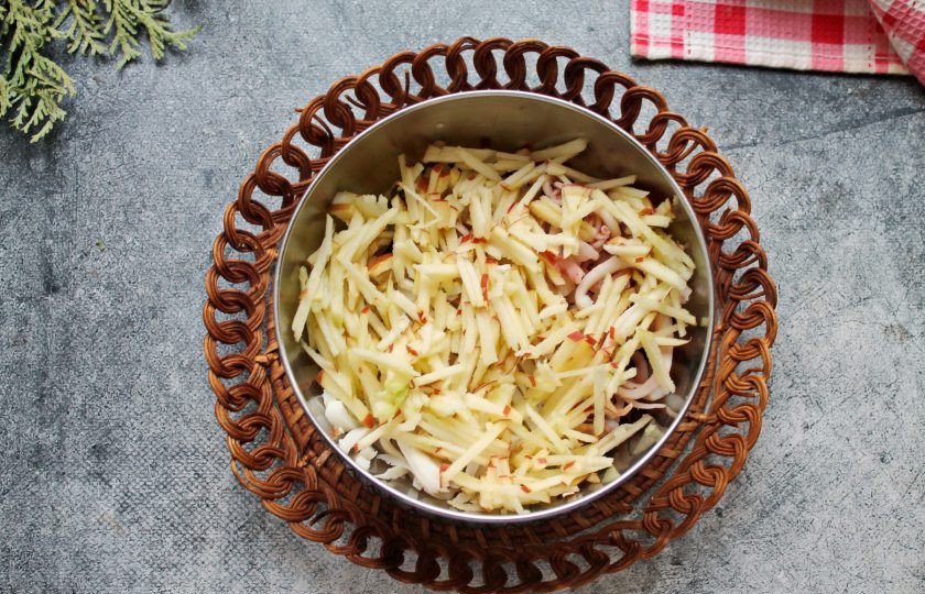 1. Этап. Салат с огурцом, кальмаром и яблоком: Яблоко разрежьте на четыре части, удалите сердцевину и порежьте тонкой соломкой. Добавьте яблоко в салат.