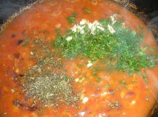 1. Этап. Гуляш из фасоли: Добавляем сваренную фасоль. Если фасоль не покрыта подливой, добавим немного воды. Солим, добавляем специи и зелень с чесноком, готовим минут 10-15.