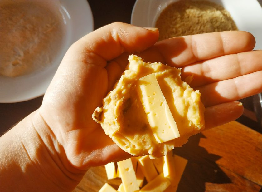 1. Этап. Испанские крокеты: Сформируем крокеты. Выложите куриный фарш на влажную ладонь, сделайте из него лепешку и положите в центр кусочек сыра.