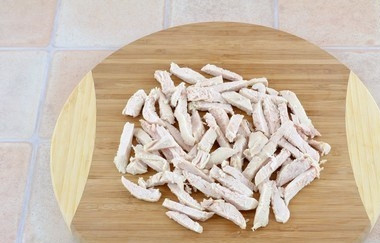 1. Этап. Куриный салат с ветчиной и опятами: Наберите в кастрюльку воду, закипятите ее. Положите в воду куриную грудку, варите ее полчаса до полной готовности. Остудите грудку, нарежьте ее соломкой так же, как и ветчину.