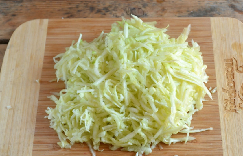 1. Этап. Драники из кабачков: Натрите кабачки на крупной терке, оставьте на 10 минут, а затем отожмите выделившийся сок.