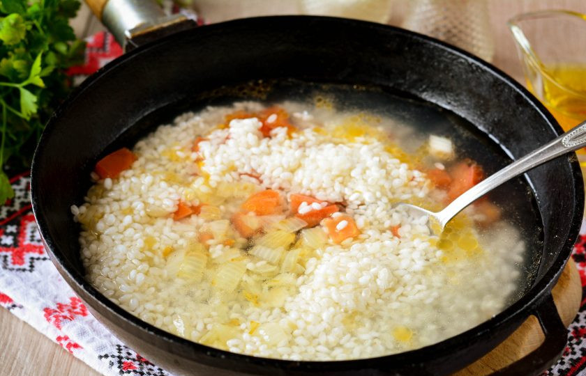 1. Этап. Рассыпчатый рис в сковороде: Влейте горячую воду и томите рис на медленном огне под крышкой 20 минут, пока не выпарится вся жидкость.