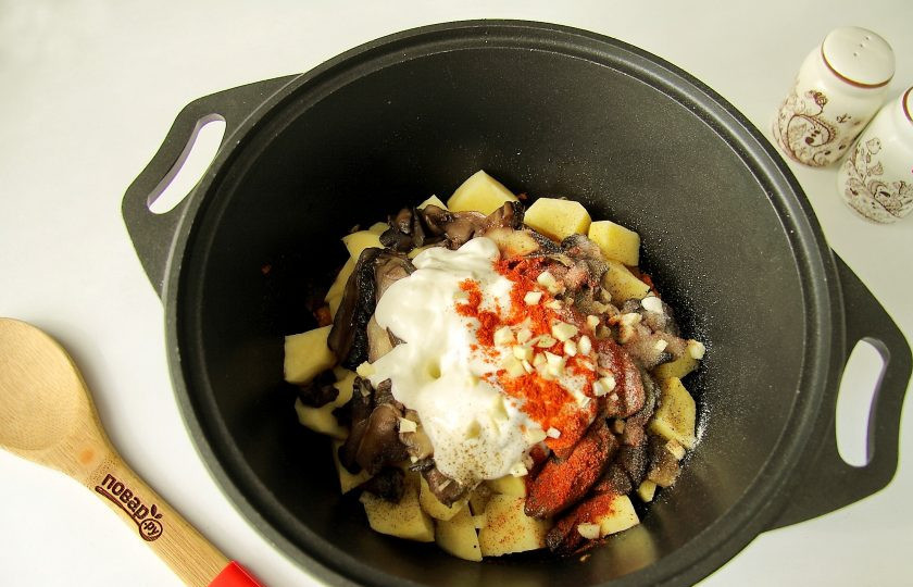 1. Этап. Рагу с краковской колбасой: Добавьте сметану, измельченный ножом чеснок, посыпьте все солью и специями.