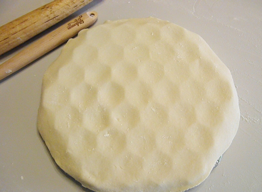 1. Этап. Пельмени с сыром в духовке: Положите присыпанной стороной вниз лист теста на пельменницу.