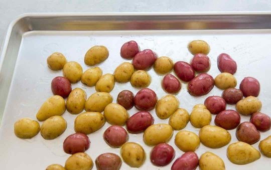 1. Этап. Рецепт семги в духовке с картошкой: Картофель необходимо хорошо помыть и высушить, разрезать пополам и посолить. Затем выкладываем картошку на противень и поливаем оливковым маслом. Отправляем в разогретую до 200 градусов духовку на 10 минут.