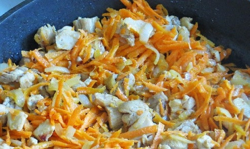 1. Этап. Капуста, тушенная с курицей и помидорами: Чистим морковку, натираем ее на крупной терке. Добавляем на сковороду еще растительного масла и морковь. Перемешиваем и обжариваем минуты 3.