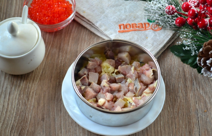 1. Этап. Сельдь под дорогой шубой: Сельдь порежьте на мелкие кусочки и выложите вторым слоем. Снова смажьте майонезом.