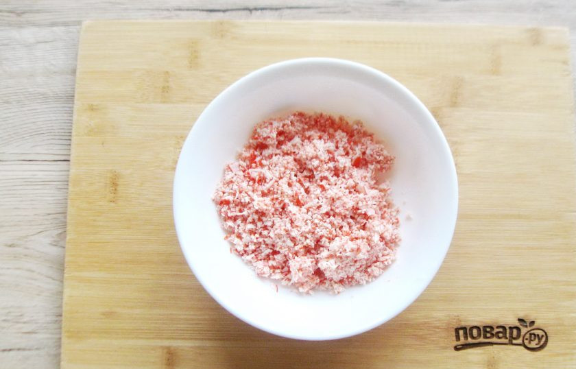 1. Этап. Яйца фаршированные крабовыми палочками и сыром: Крабовые палочки измельчите в измельчителе или пропустите через мясорубку. Переложите в миску.