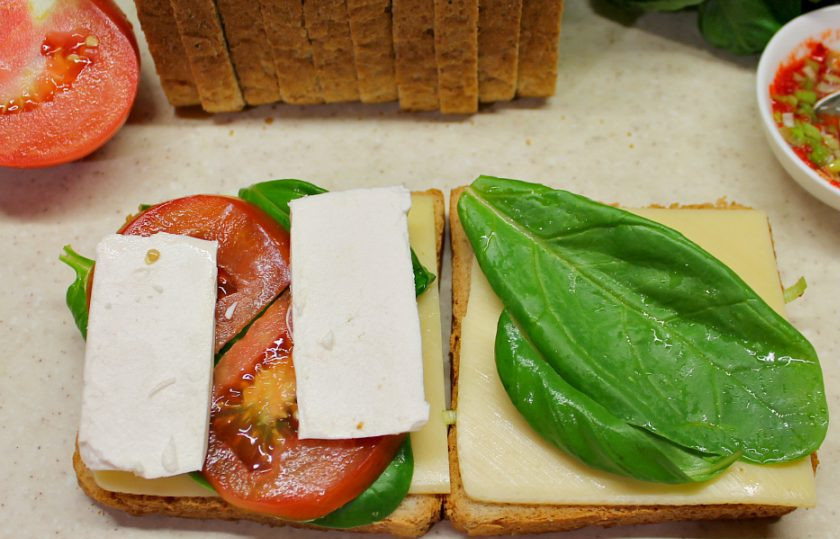 1. Этап. Панини на гриле: Добавляем нарезанный тонкими ломтиками помидор и фету. 2 части панини соединяем.