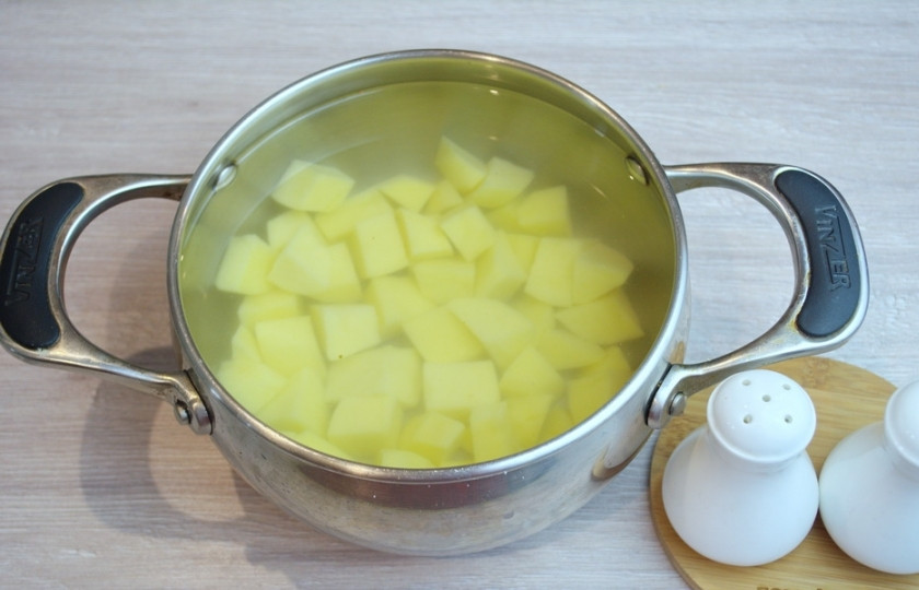 1. Этап. Суп с фасолью и лапшой: Очищенный картофель нарежьте кубиком и поместите в кастрюлю. Залейте его водой и поставьте вариться. Когда вода закипит, добавьте немного соли. Это придаст вкус не только бульону, но и самому картофелю.