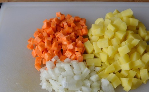 1. Этап. Густая похлёбка с фрикадельками и шпинатом: Лук, морковь и картофель чистим. Лук и морковь режем мелкими кубиками, картофель кубиками покрупнее.