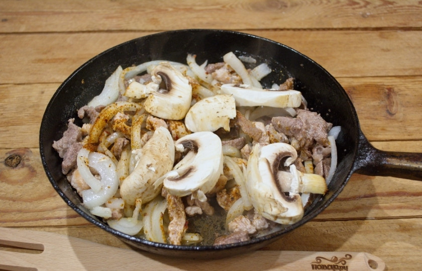 1. Этап. Скоблянка: К мясу добавляем подготовленный лук и специи. Тушим все, накрыв крышкой. Можно подлить полстакана воды, чтобы мясо хорошо приготовилось. Добавьте нарезанные шампиньоны. Тушите все вместе.