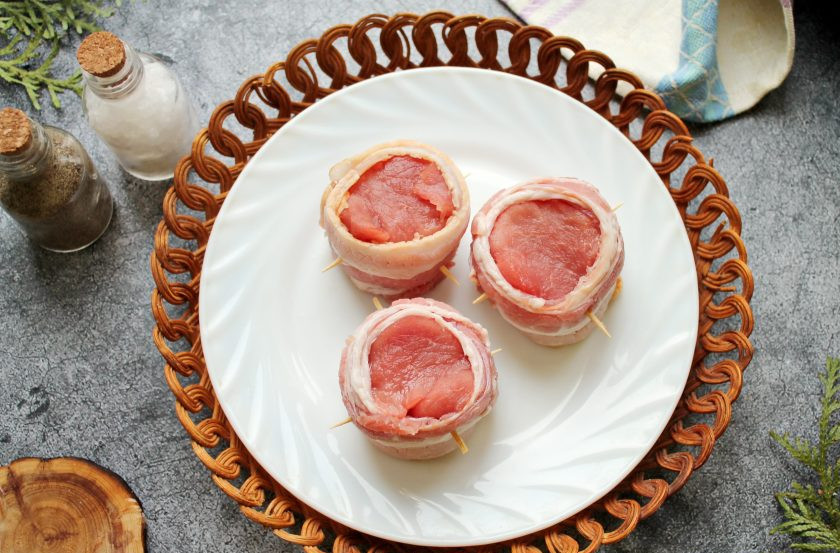 1. Этап. Медальоны с грибами: Вырезку острым ножом зачистите от пленок и жил, сполосните и обсушите. Порежьте ее на кусочки толщиной 4 сантиметра, посолите и поперчите. Обверните каждый кусочек в бекон и закрепите его зубочистками. Дайте медальонам постоять 15-20 минут.