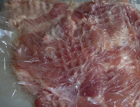 1. Этап. Куриный рулет в аэрогриле: Достаем курицу. Отделяем филе от костей так, чтобы оно отходило пластами. Это может быть грудка или окорочка. Если вы купили уже разделанное куриное филе, то просто промойте его и выложите на разделочную доску. Берем специальный молоточек и отбиваем куриное мясо. Так как курица нежная, можете положить сверху полиэтиленовую пленку.