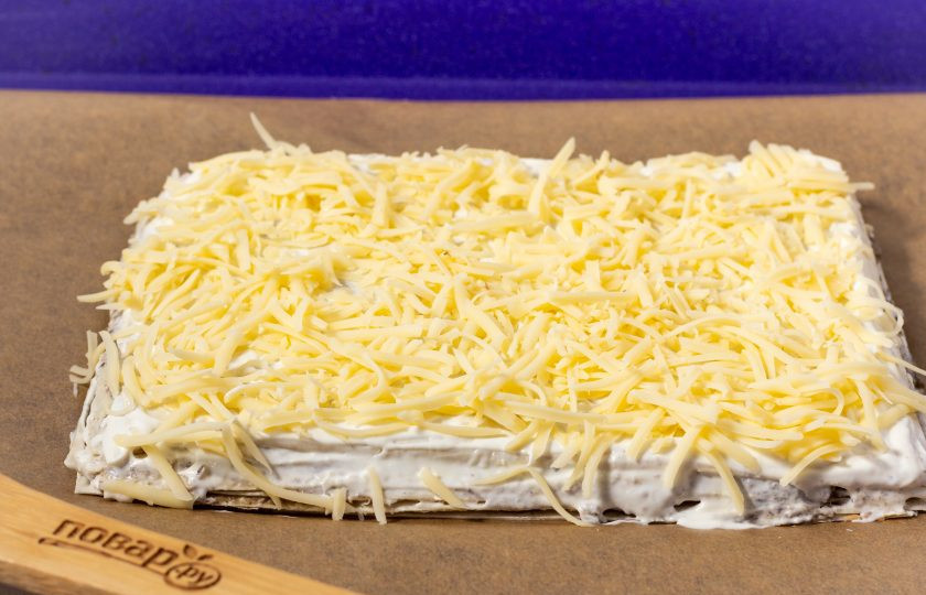 1. Этап. Торт из лаваша с грибами: Присыпьте натертым на мелкой терке сыром.
