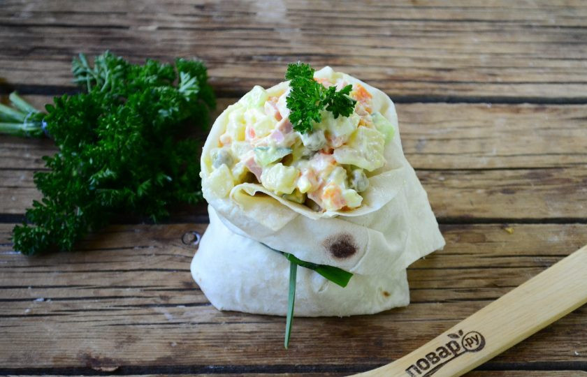 1. Этап. Салат Оливье в лаваше: На лист лаваша положите несколько столовых ложек салата, подверните края с трех сторон и закрепите пером лука или чеснока, чтобы получился мешочек. В таких мешочках очень удобно подавать салаты порционно. Приятного аппетита!