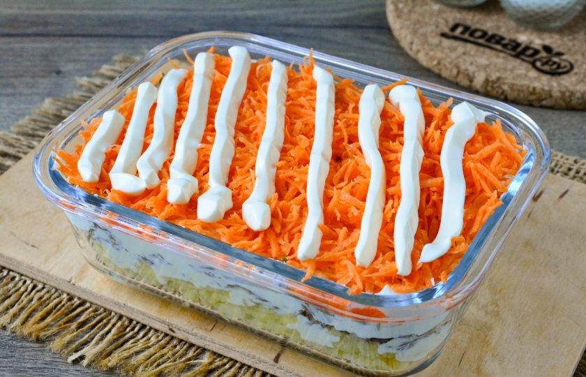 1. Этап. Салат Президент с мясом: Следующий слой — натертая на мелкой терке сырая морковь. Полейте этот слой чесночным майонезом. Посолите по вкусу.