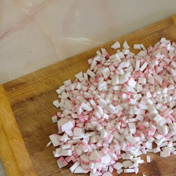 1. Этап. Салат Оксанка: Крабовые палочки мелко порезать. Уложить равномерным слоем на блюдо и смазать майонезом.