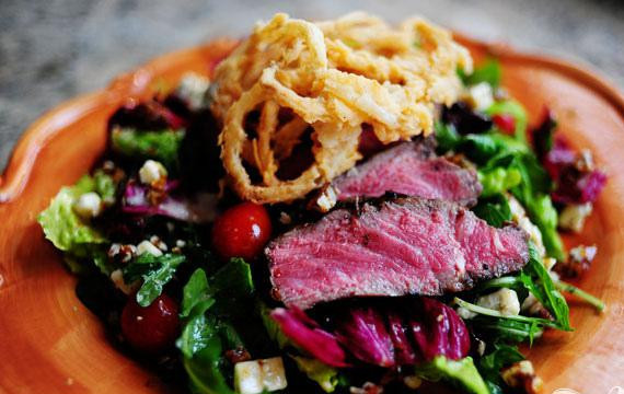 1. Этап. Салат со стейком: 7. Выложить салат на тарелки. Сверху выложить ломтики говяжьего стейка и луковые кольца. Подавать сразу же.