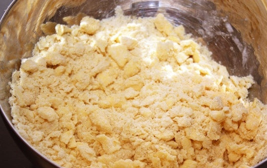 1. Этап. Быстрый пирог с консервированными персиками: 2. В миску к маслу добавьте муку и пятьдесят грамм сахара. Все ингредиенты разотрите до получения однородной и мелкой крошки, удобней всего это делать руками (чем меньше, тем лучше).