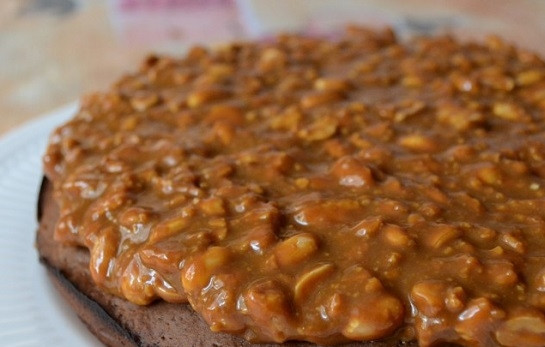 1. Этап. Торт Сникерс с крекером: 9. Выложите на тарелку корж и при желании пропитайте его сладким сиропом, кофе или алкоголем, например. Ровным слоем распределите ореховую массу.